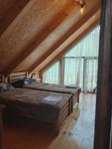 a bedroom with two beds and a large window at Tsiskari in Tsaldashi