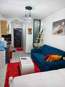 a living room with a blue couch and a red rug at GCurtway Homes Tsavo Superior Studios in Nairobi