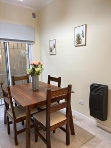 a dining room table with chairs and a television at Punto San Martin in Venado Tuerto +7 photos