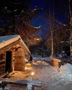 a person sitting outside a cabin in the snow at night at Lillstugan in Sälen