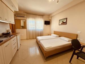 a small bedroom with a bed and a kitchen at Thoma's K Studios in Vlorë