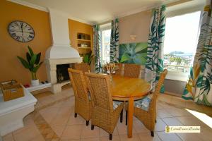 a dining room with a table and chairs and a clock at Duplex Luxe Vue Mer Face Palais des Festivals et Vieux Port 5 Couchages in Cannes