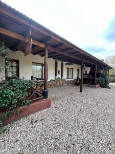 a building with a roof on a gravel yard at Cabañas El Campo in Sierra de la Ventana