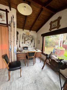 a room with a desk and chairs and a window at Cabañas El Campo in Sierra de la Ventana