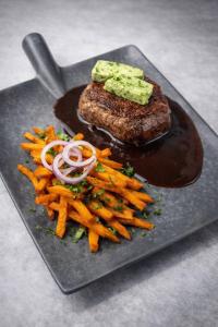 a black plate with a steak and fries and sauce at Lillstugan in Sälen +42 photos
