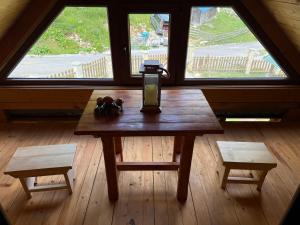 a table with a candle on it in a room with windows at Naš raj in Berane +15 photos