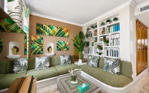 a living room with a green couch and bookshelves at Duplex Luxe Vue Mer Face Palais des Festivals et Vieux Port 5 Couchages in Cannes