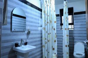 a bathroom with a sink and a shower at Kingram Apartments in Entebbe +26 photos