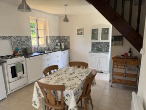 a kitchen with a table and chairs in a kitchen at Orchid Cottage in Gorges +21 photos