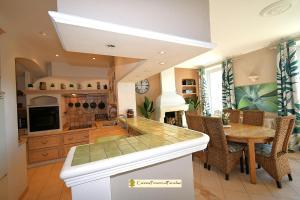 a kitchen with a table and a dining room at Duplex Luxe Vue Mer Face Palais des Festivals et Vieux Port 5 Couchages in Cannes