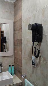 a bathroom with a sink and a phone on the wall at Duplex Atenea in Chivilcoy +17 photos