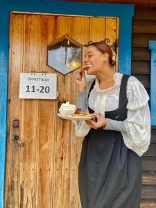 a woman eating a plate of food in front of a door at Lillstugan in Sälen