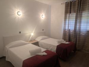a hotel room with two beds and two tables at Casa dos Fetos Varanda Panorâmica & Natureza in Ourém