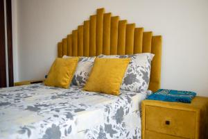 a bed with a wooden headboard in a bedroom at Martil Plage Piscine Fibre & Netflix in Martil +29 photos