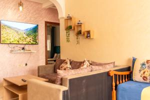 a living room with a couch and a tv at Martil Plage Piscine Fibre & Netflix in Martil