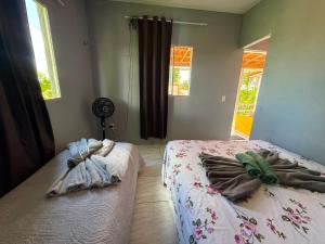 a bedroom with two beds with towels on them at Suite em Mulungu in Mulungu