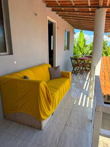 a yellow couch on a patio with a table at Suite em Mulungu in Mulungu +17 photos