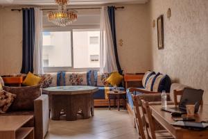 a living room with a couch and a table at Martil Plage Piscine Fibre & Netflix in Martil