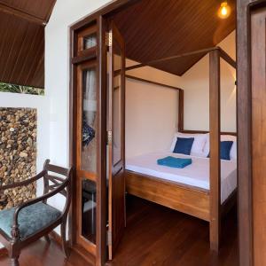 a bedroom with a canopy bed and a chair at Forest River Escape Ella in Ella