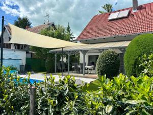 a house with a canopy over a pool at Johanna Balatoni Ház in Balatonfenyves