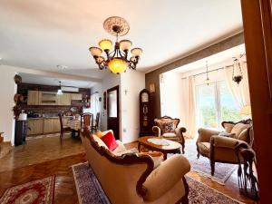 a living room with a couch and chairs and a chandelier at Villa Terrazza in Donji Morinj