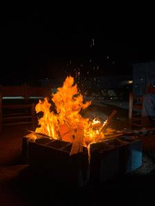 eine Feuerstelle mit Flammen in der Nacht in der Unterkunft Aska camp in Oulad Akkou