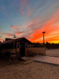 ein Gebäude am Strand mit einem Sonnenuntergang im Hintergrund in der Unterkunft Aska camp in Oulad Akkou + 5 Fotos