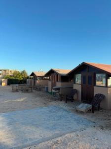 ein Gebäude mit Stühlen und einem Picknicktisch daneben in der Unterkunft Aska camp in Oulad Akkou