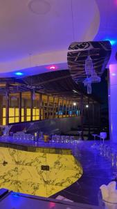 eine Bar mit blauen Lichtern und Gläsern auf einem Tisch in der Unterkunft Aska camp in Oulad Akkou