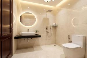 a bathroom with a toilet and a sink and a mirror at Hotel Aarav Grand Chandigarh in Chandīgarh +1 photo
