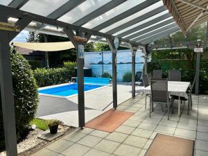 a patio with a pergola and a swimming pool at Johanna Balatoni Ház in Balatonfenyves