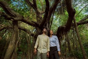 a man and a woman standing in front of a tree at Sanctuary Amaidiyana - A CGH Earth Experience in Pondicherry