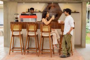 a man and a woman standing at a bar at Sanctuary Amaidiyana - A CGH Earth Experience in Pondicherry