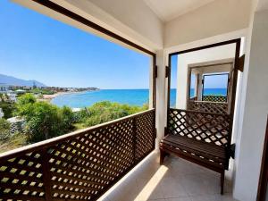 a balcony with a bench looking out at the ocean at Riviera Beach Bungalows in Kyrenia