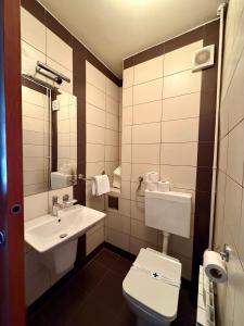 a bathroom with a white toilet and a sink at Hotel Kutina in Kutina +19 photos