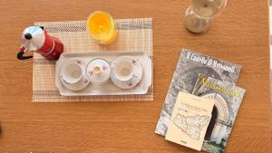 a table with a tray with two cups and a magazine at Casa Manzoni- Appartamento con terrazzo in centro in Mussomeli