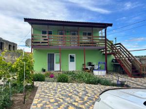 a green house with a deck on top of it at Зелений двір in Vapnyarka