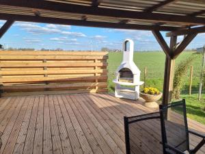 a wooden deck with a fireplace on a fence at Ferienhaus AKate - Sauna, Kamin, Garten, 3 Hunde in Kronprinzenkoog