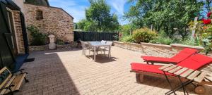 a patio with a table and chairs and a table and chairs at Le gîte des Sorbiers in Charmes-lès-Langres