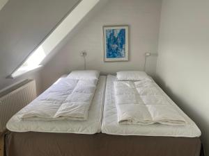 a bedroom with two beds in a attic at Tversted Strandpark in Bindslev