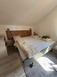 a bedroom with a large bed with a wooden headboard at Alpes Ski SUPERDEVOLUY in Le Dévoluy
