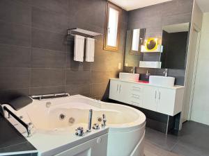 a bathroom with a white tub and a sink at Au Lavoir in Colombiers +62 photos