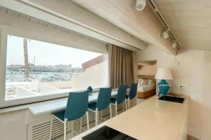 a dining room with a table and chairs and a window at Marina Homes Sea View Ortigia in Syracuse