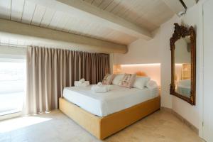 a bedroom with a large bed and a mirror at Marina Homes Sea View Ortigia in Syracuse