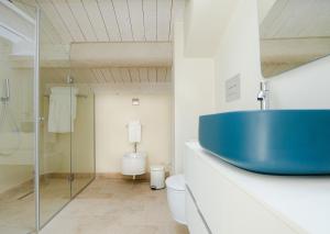 a bathroom with a blue sink and a toilet at Marina Homes Sea View Ortigia in Syracuse +50 photos
