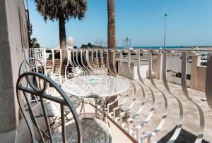 a table and chairs on a balcony overlooking the beach at Marina Homes Sea View Ortigia in Syracuse