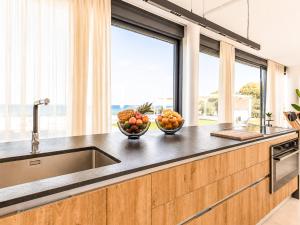 a kitchen with two bowls of fruit on a counter at Miguel Luxury Beach Front Villa in Fánai +39 photos