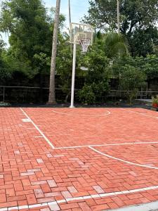 a red brick basketball court with a basketball hoop at Lakeside Meadows- Diamond Homestay in Kollam