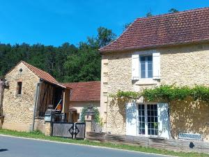 an old stone house on the side of the road at Villa EsquirHall, chambres d'hôtes in Journiac