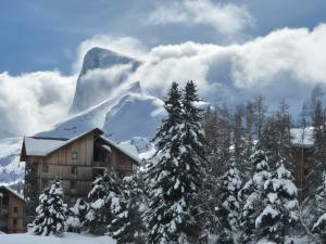 a ski lodge with a snow covered mountain in the background at Alpes Ski SUPERDEVOLUY in Le Dévoluy